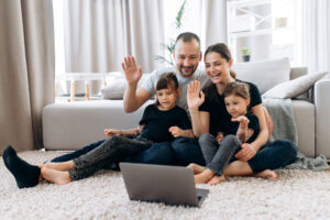 Family of 4 on a video call on their living room floor